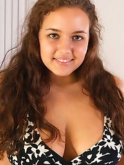 Pretty curled hair teen exposes her great curves including firm big tits and plays with an orange